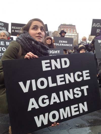 Women holding placard saying "End violence against women"